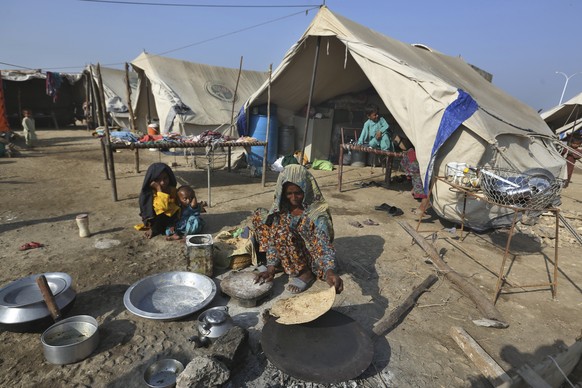A woman makes local bread called 'Roti' for her family at a relief camp in Qambar Shahdadkot, a flood-stricken district in Sindh province, Pakistan, October 2018. 25, 2022. Floor level...