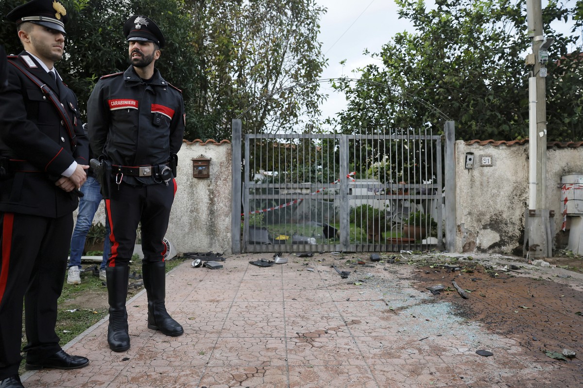 Parts of a car are seen on the ground as Carabinieri military police stand outside the home of investigative journalist Sigfrido Ranucci after an explosive device detonated under the car, in Pomezia,  ...