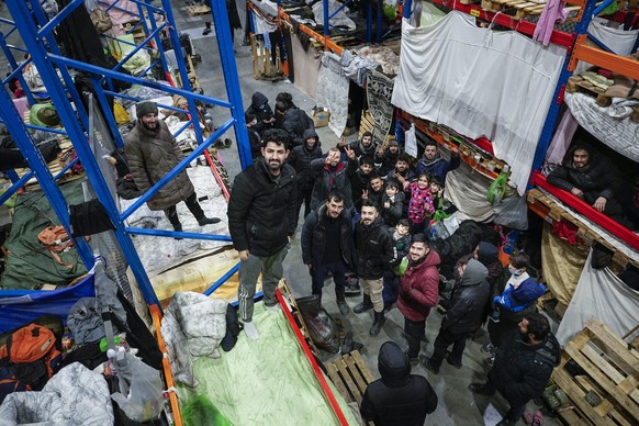 Migrants pose for a photographer at the &quot;Bruzgi&quot; checkpoint logistics center at the Belarus-Poland border near Grodno, Belarus, Tuesday, Dec. 21, 2021. Since Nov. 8, a large group of migrant ...