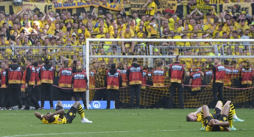 Dortmund&#039;s players lay on the pitch after the German Bundesliga soccer match between Borussia Dortmund and FSV Mainz 05 in Dortmund, Germany, Saturday, May 27, 2023. (AP Photo/Michael Probst)