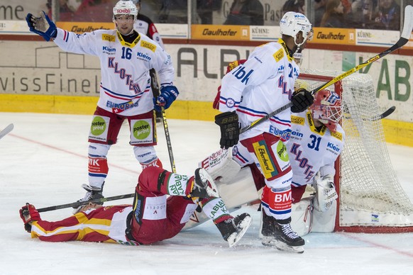 Tigers Mikael Johansson, unten, kaempft um den Puck, gegen Klotens Daniele Grassi, Clarence Kparghai, Goalie Kevin Poulin, von links, waehrend dem Meisterschaftsspiel der National League, zwischen den ...