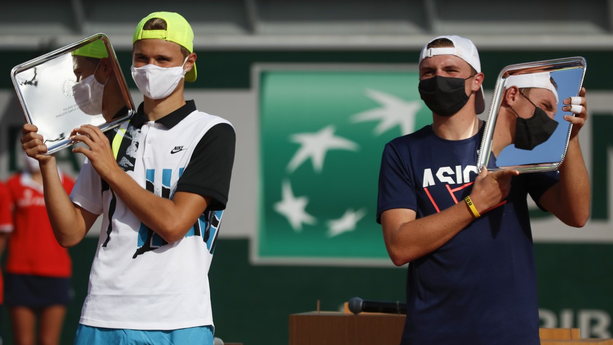Switzerland's Dominic Stephan Stricker, right, holds the trophy after winning the junior men's final match of the French Open tennis tournament against Switzerland's Leandro Riedi, left ...