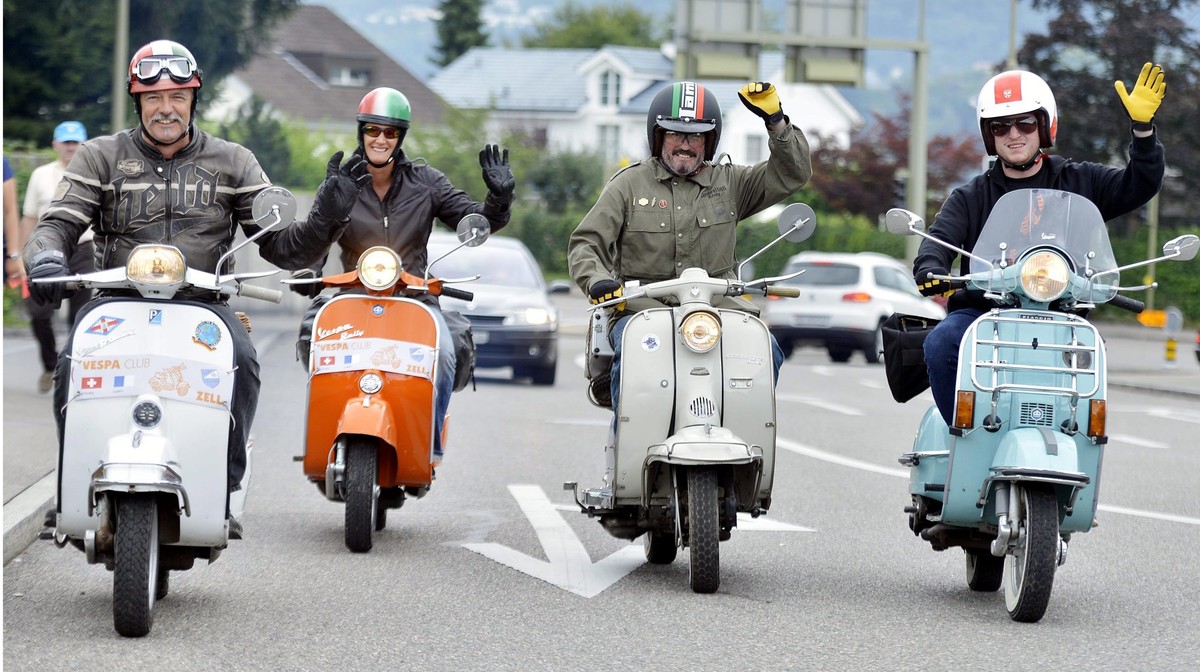 Winken fuer den Fotografen am Vespatreffen in Meilen am Samstag, 25. August 2012. Die rollende "Italianita" zeugt vom ungebrochenen Appeal des legendaeren Rollers. (KEYSTONE/Walter Bieri)