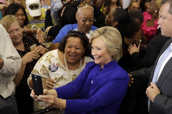 Democratic presidential candidate Hillary Clinton takes a selfie as she meets with attendees during a campaign stop at the Frontline Outreach Center in Orlando, Fla., Wednesday, Sept. 21, 2016. (AP Ph ...