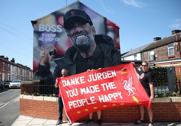 epa11352829 Fans pose with a banner in front of a mural of Liverpool manager Jurgen Klopp ahead of the English Premier League soccer match of Liverpool FC against Wolverhampton Wanderers in Liverpool, ...
