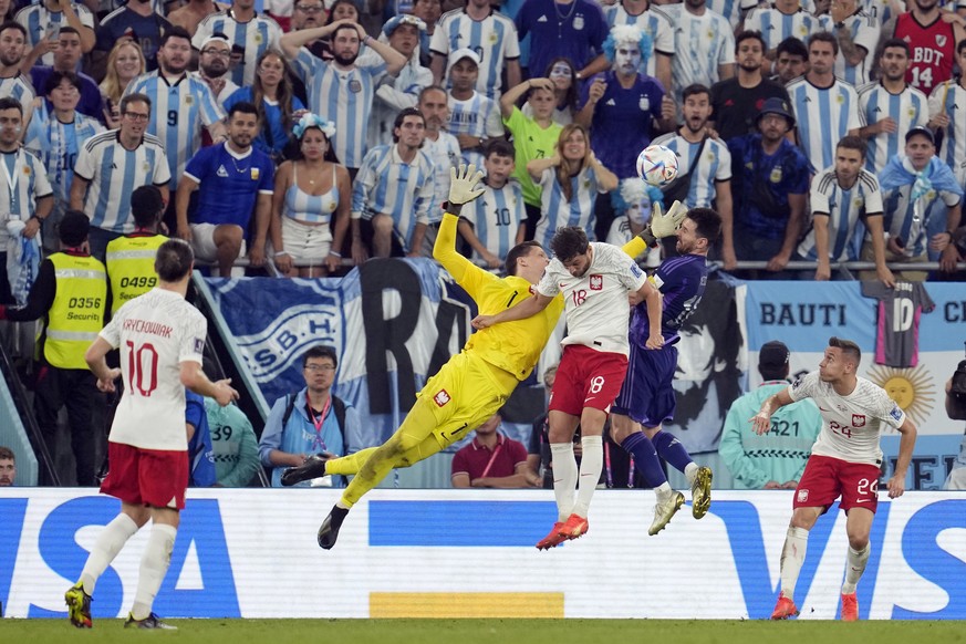 Poland&#039;s goalkeeper Wojciech Szczesny (1) leaps for the ball against Argentina&#039;s Lionel Messi and Poland&#039;s Bartosz Bereszynski during the World Cup group C soccer match between Poland a ...
