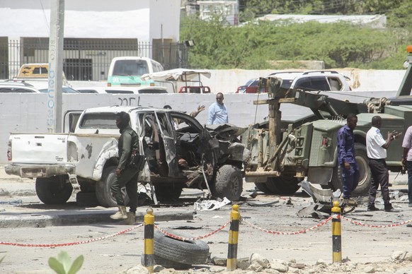 epa09939639 Security officials at the scene of a suicide bomb blast at a security checkpoint leading to Aden Adde International Airport in Mogadishu, Somalia, 11 May 2022. The Islamist militant group, ...