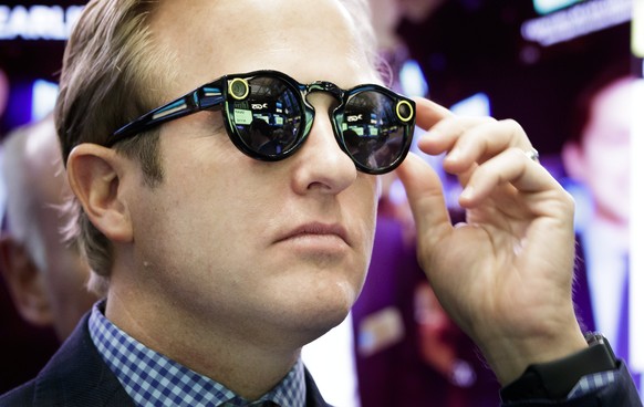 epa06137935 (FILE) - A banker wearing Snapchat Spectacles watches the initial public offering of Snap Inc, the parent company of Snapchat, at the New York Stock Exchange in New York, New York, USA, on ...