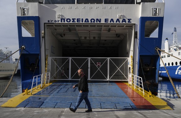 A man walks past a docked ferry at the port of Piraeus, near Athens, during a 24-hour ferry strike , on Thursday March 16, 2023. Strikes by labor unions in Greece following a rail disaster last month  ...