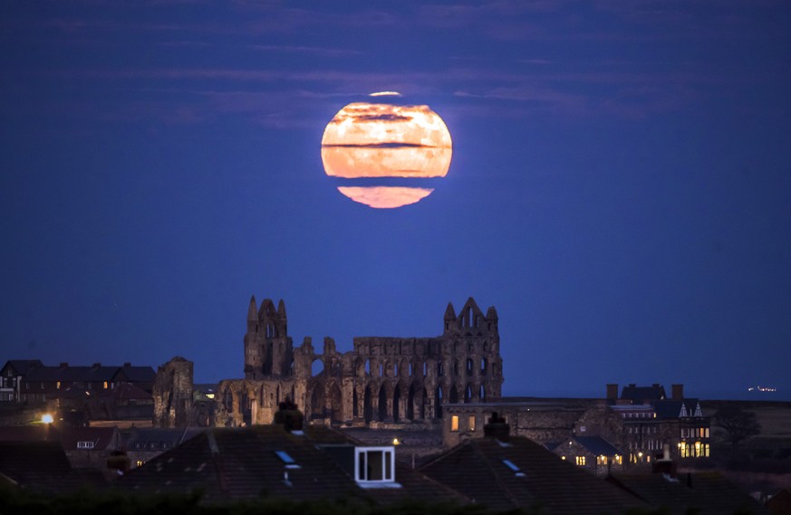 The Supermoon rises above Whitby Abbey in Whitby, north east England, Sunday Dec. 3, 2017. The Dec. 3 full moon will be the first of three consecutive supermoons. (Danny Lawson/PA via AP)