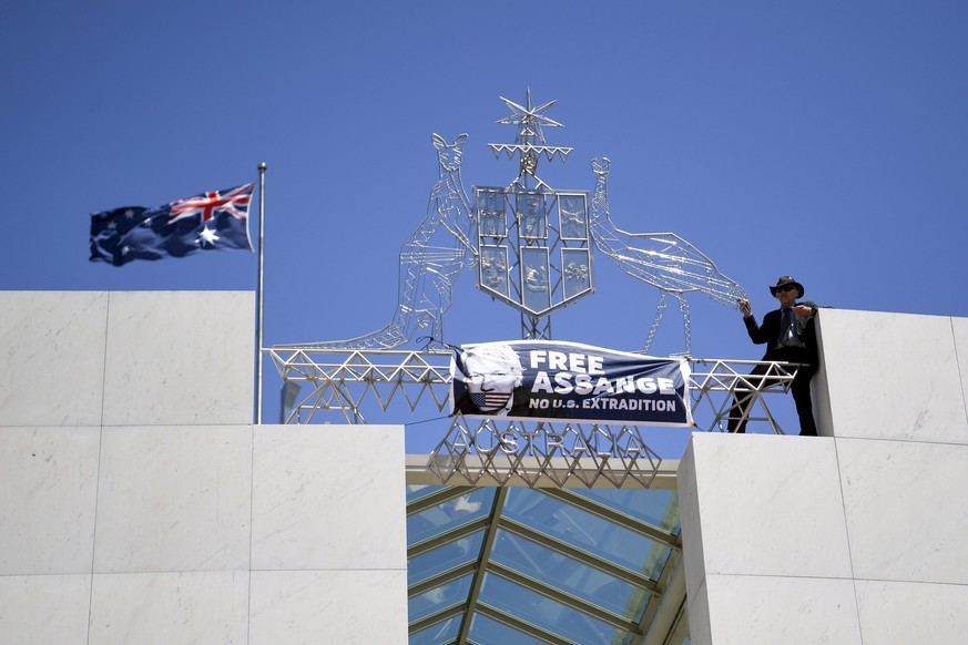 epa07987282 A protester demanding the release of Julian Assange stands on top of Parliament House in Canberra, Australia, 11 November 2019. EPA/LUKAS COCH AUSTRALIA AND NEW ZEALAND OUT
