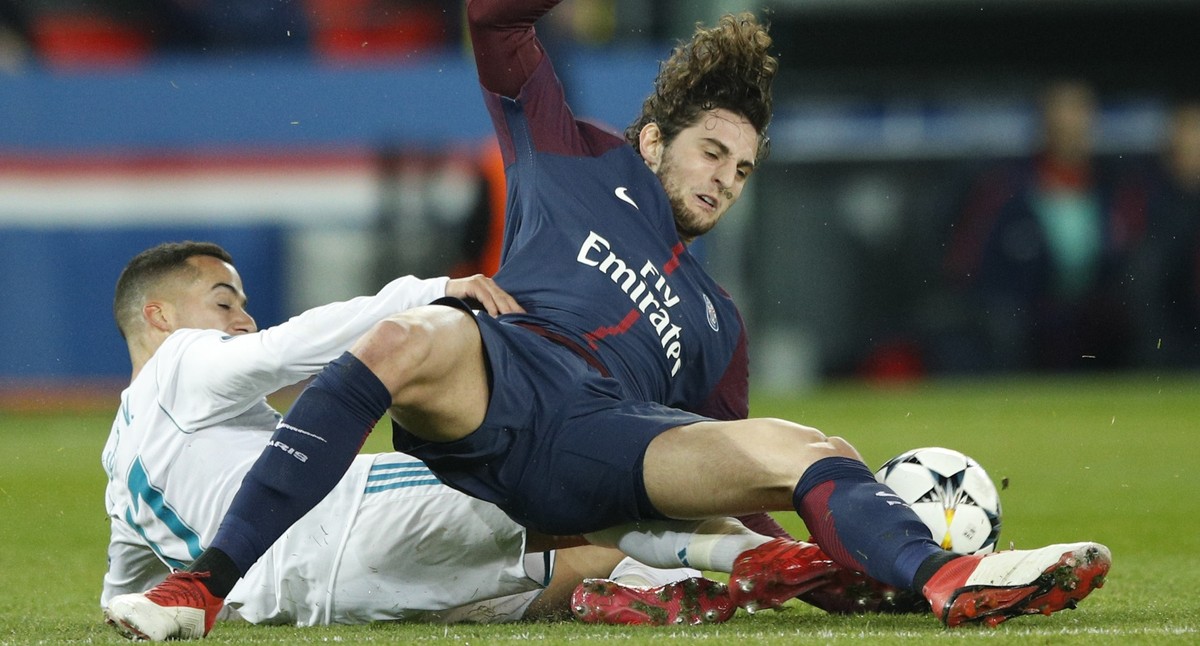 Real Madrid's Lucas Vazquez, left, stops PSG's Adrien Rabiot during the round of 16, 2nd leg Champions League soccer match between Paris Saint-Germain and Real Madrid at the Parc des Princes ...