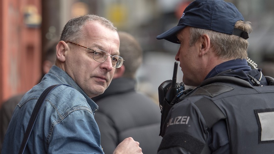 Der Basler Grossrat Eric Weber, links, der Initiant der zunaechst bewilligten und dann zurueckgezogenen Pegida Demonstration in Basel, spricht mit einem Polizisten am Mittwoch, 3. Februar 2016. Ein gr ...