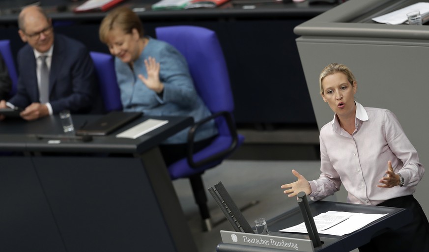 German Finance Minister Olaf Scholz, left, and German Chancellor Angela Merkel, 2nd left, attend the speech of Alice Weidel, right, co-faction leader of the Alternative for Germany party, during a mee ...