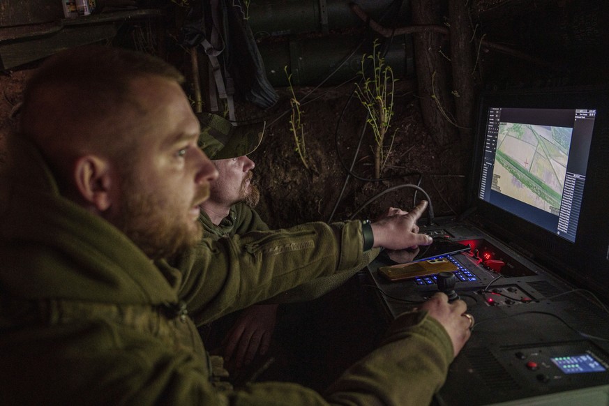 Ukrainian servicemen Anatolii and Dmytro of 148th separate artillery brigade of the Air Assault Forces correct fire during flight over Russian positions by a Furia drone at the frontline in Donetsk re ...