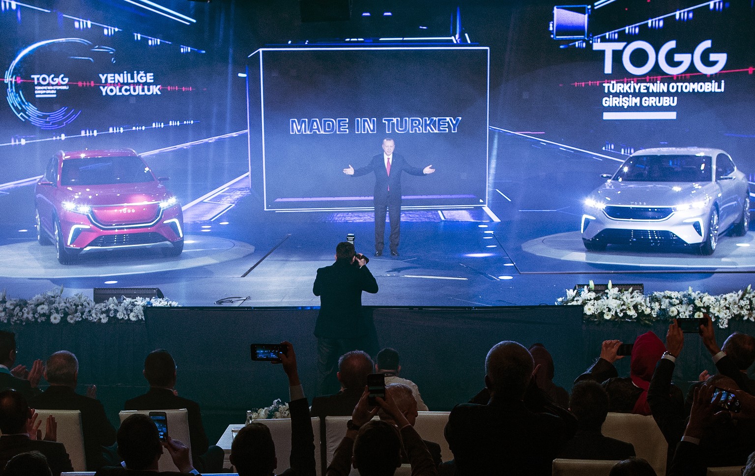 epa08091840 Turkish President Recep Tayyip Erdogan (C) waves during a ceremony to announce the first domestically-designed Turkish TOGG automobile prototypes in the Gebze district of Kocaeli, Turkey,  ...