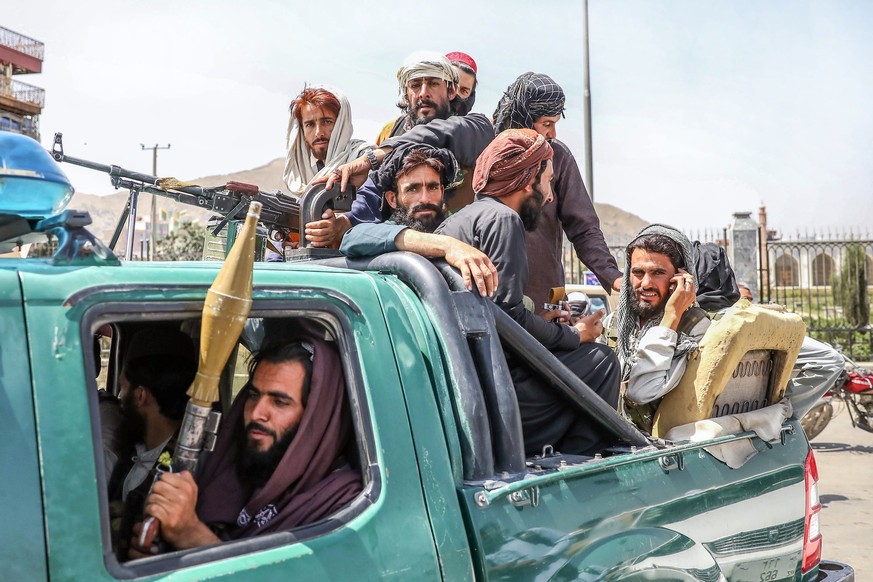 epaselect epa09416403 Taliban fighters are seen on the back of a vehicle in Kabul, Afghanistan, 16 August 2021. Taliban co-founder Abdul Ghani Baradar, on 16 August 2021, declared victory and an end t ...