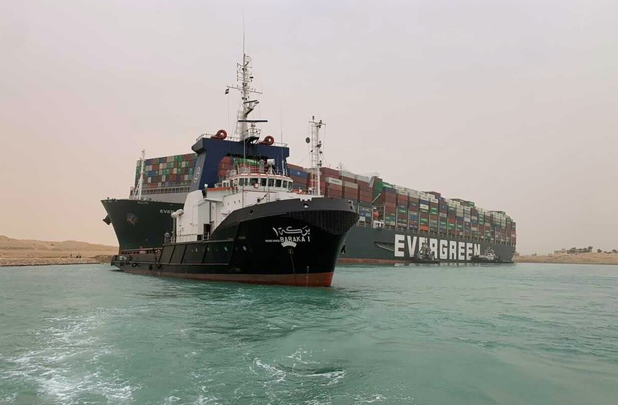 CORRECTS NAME OF SHIP TO EVER GIVEN, NOT EVER GREEN - In this photo released by the Suez Canal Authority, a boat navigates in front of a cargo ship, Ever Given, Wednesday, March 24, 2021, after it bec ...