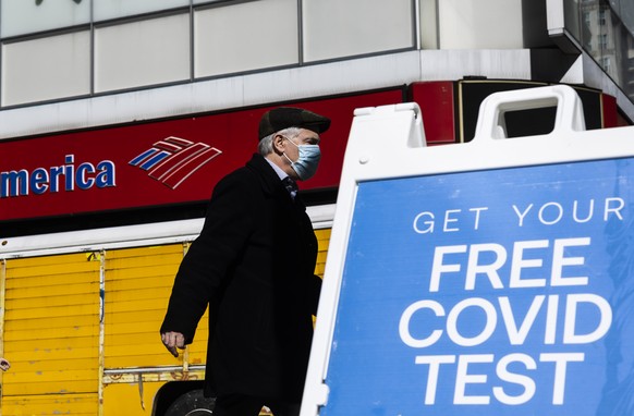 epa09745219 A person wearing a mask walks though the Midtown neighborhood of New York, New York, USA, 10 February 2022. States around the country are lifting mask mandates in public spaces, and in som ...