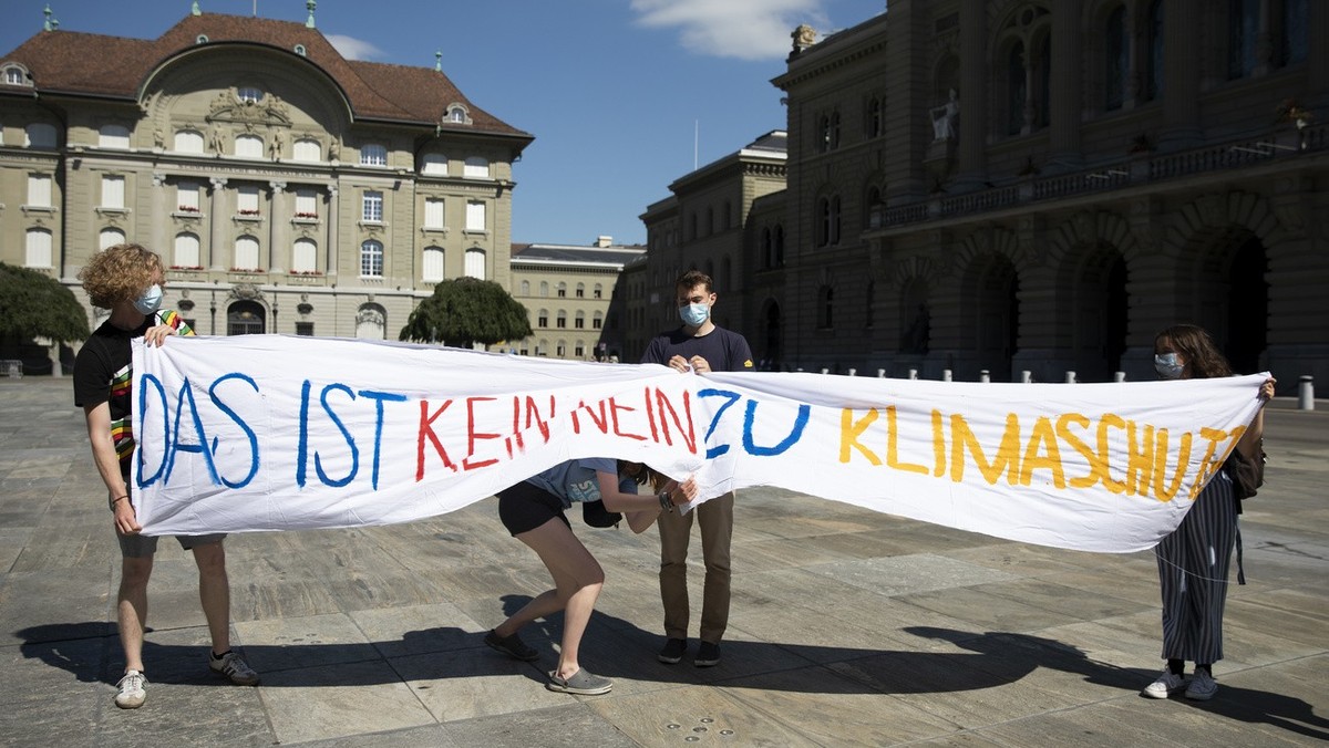 Mitglieder des Klimastreiks halten Banner hoch, vor einer kurzfristig anberaumten Medienkonferenz auf dem Bundesplatz, am Sonntag, 13. Juni 2021, in Bern. (KEYSTONE/Peter Klaunzer)