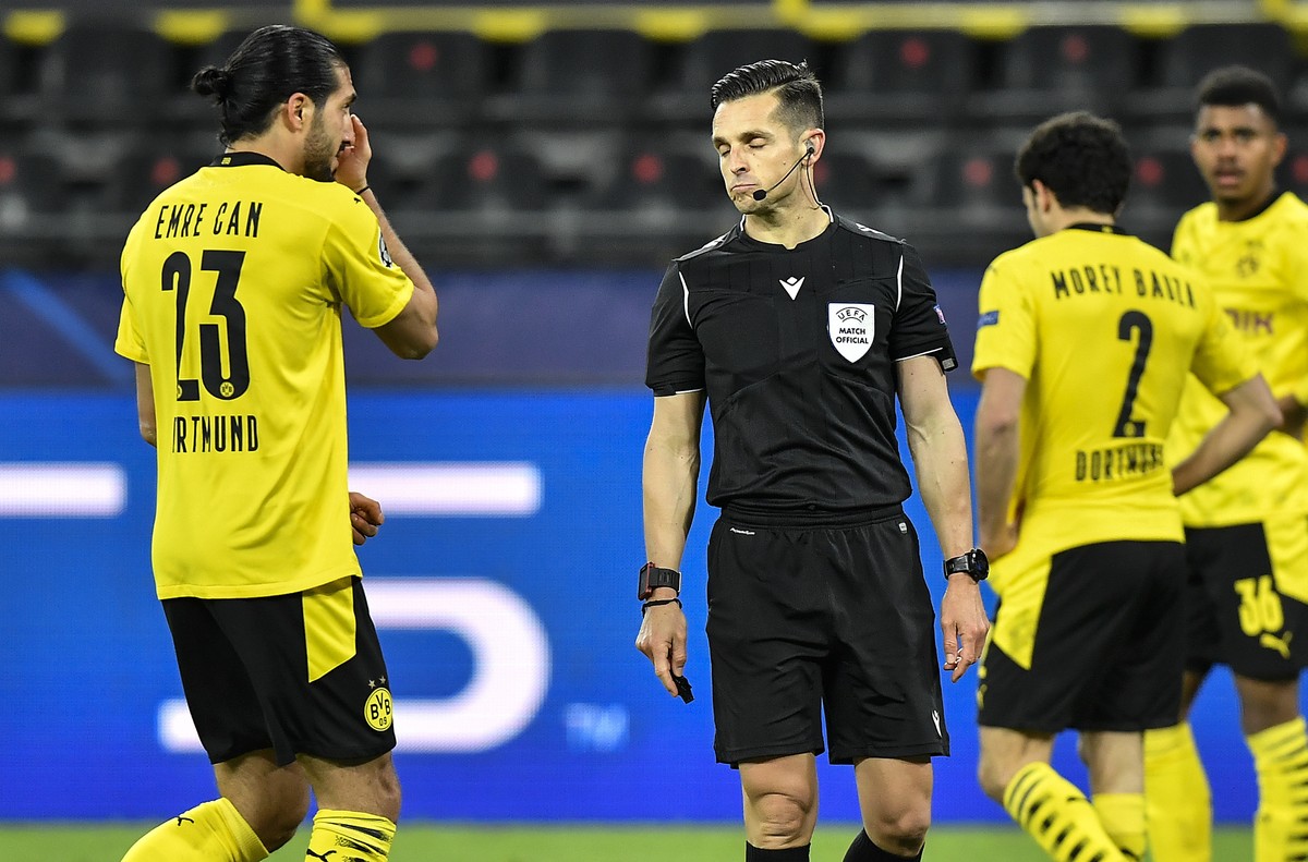 Dortmund's Emre Can, left, talks to referee Carlos del Cerro Grande, after he decided penalty for Can using his hand during the Champions League quarterfinal 2nd leg soccer match between Borussia ...