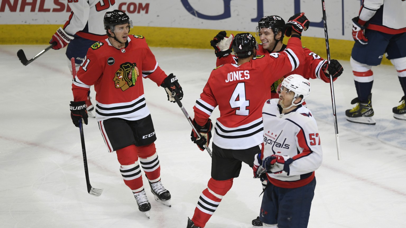 Chicago Blackhawks&#039; Philipp Kurashev celebrates with teammate Seth Jones (4) while Anthony Beauvillier looks on after scoring a goal during the second period of an NHL hockey game against the Was ...