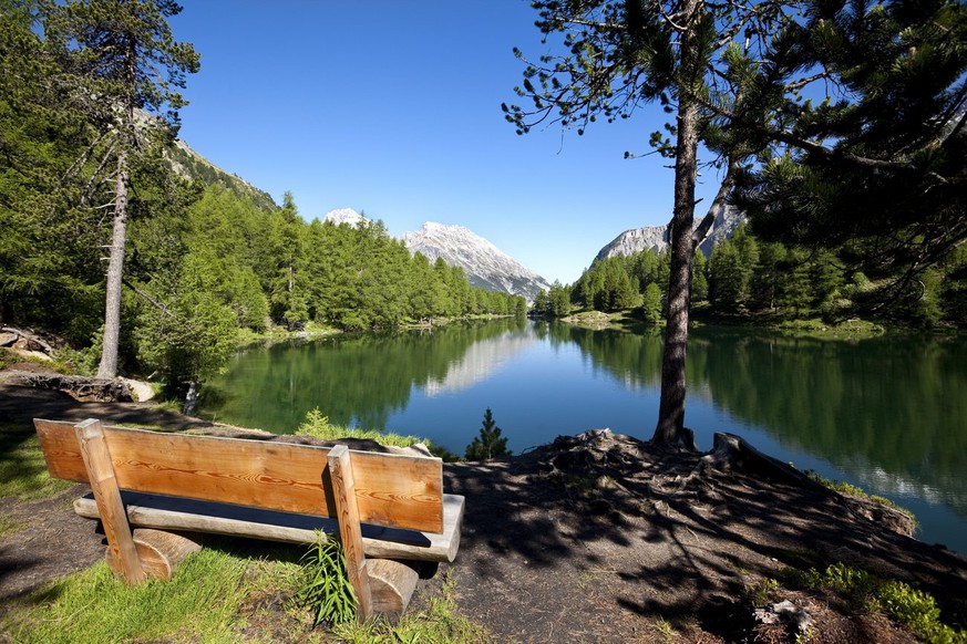 Eine Sitzbank am Ufer des Palpougnasee oberhalb Preda am Albulapass steht am Freitag, 25. Juni 2010, bei strahelndschoenem Sommerwetter fuer die Feriengaeste bereit. (KEYSTONE/Arno Balzarini)