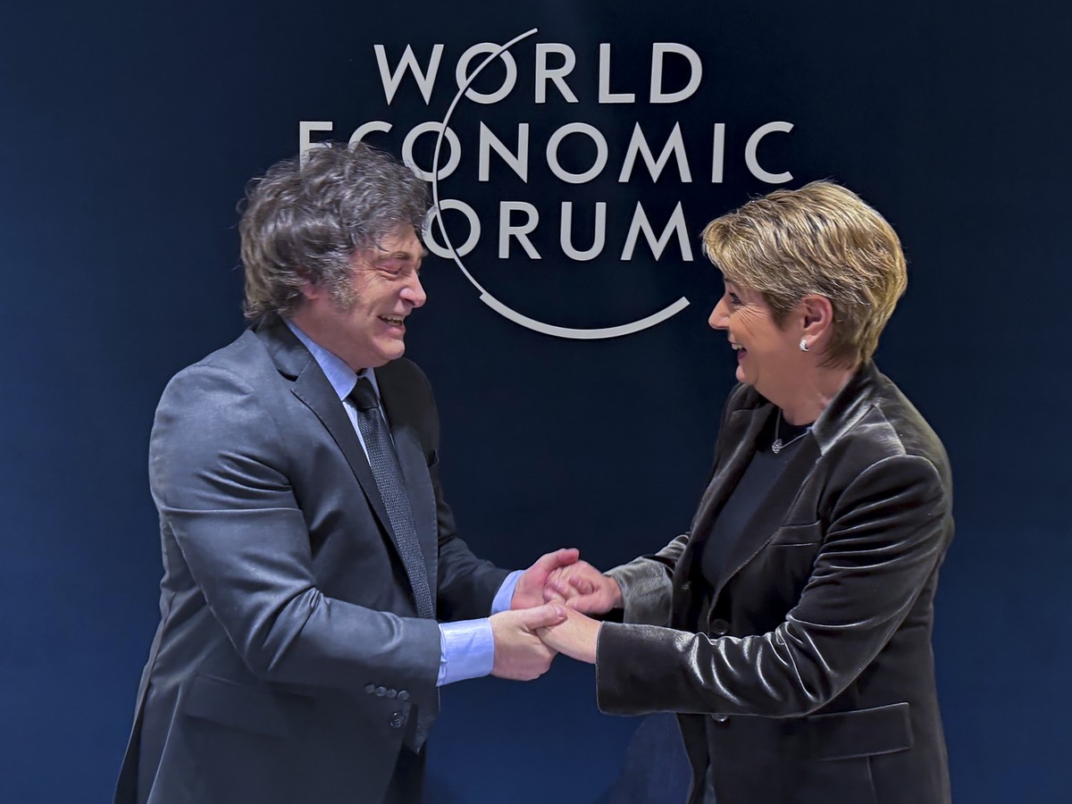 HANDOUT - Javier Milei, President of Argentina, left, shakes hands with Swiss Federal President Karin Keller-Sutter, right, prior to a bilateral meeting on the sideline of the 55th annual meeting of t ...