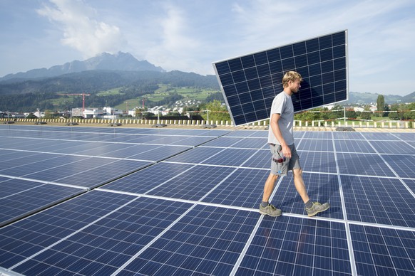Spezialisten der Firma Be Netz AG montieren die Photovoltaikanlage auf dem Dach der Swissporarena auf der Allmend in Luzern am Freitag, 2. September 2016. (KEYSTONE/Urs Flueeler)