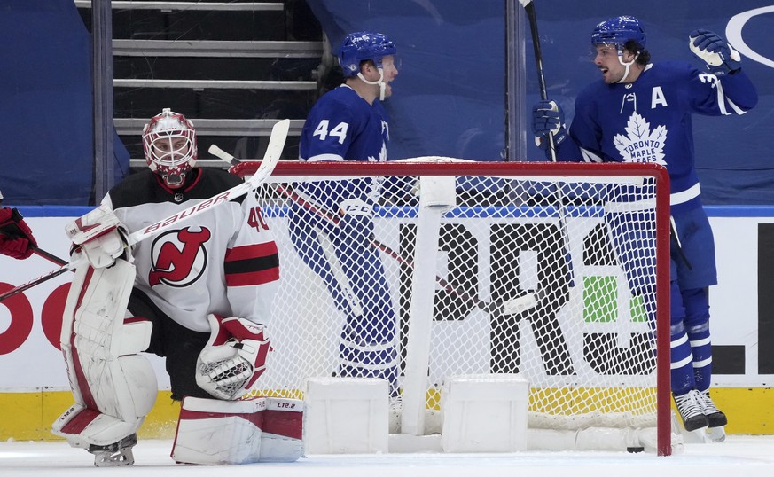 Toronto Maple Leafs forward Auston Matthews (34) celebrates his goal on New Jersey Devils goaltender Akira Schmid (40) with teammate Morgan Rielly (44) during the first period of an NHL hockey game Mo ...