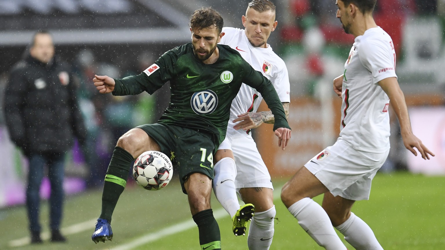 Wolfsburg&#039;s Admir Mehmedi, left, and Augsburg&#039;s Jonathan Schmid, center, challenge for the ball during the German Bundeliga soccer match between FC Augsburg and VfL Wolfsburg in Augsburg, Ge ...