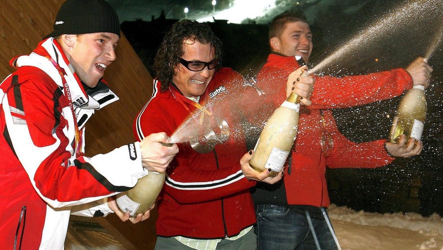 Austrian Slalom winner Benjamin Raich (L)celebrates with his compatriots second placed Reinfried Herbst (R) and third placed Rainer Schoenfelder (C) at the Austria House in Sestriere, Italy, Saturday  ...