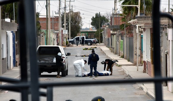 epa09730763 Forensic experts remove corpses left in the street in Fresnillo municipality, Mexico, 05 February 2022. According to official reports, 16 corpses were abandoned in the streets of Fresnillo ...