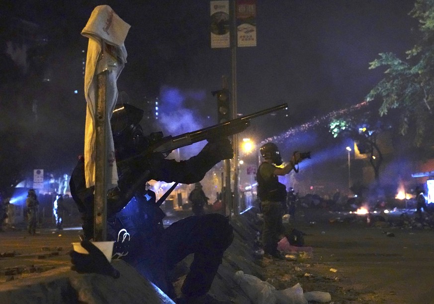 Police in riot gear prepare to fire as they move into the campus of Hong Kong Polytechnic University in Hong Kong, early Monday, Nov. 18, 2019. Hong Kong police have stormed into a university campus h ...