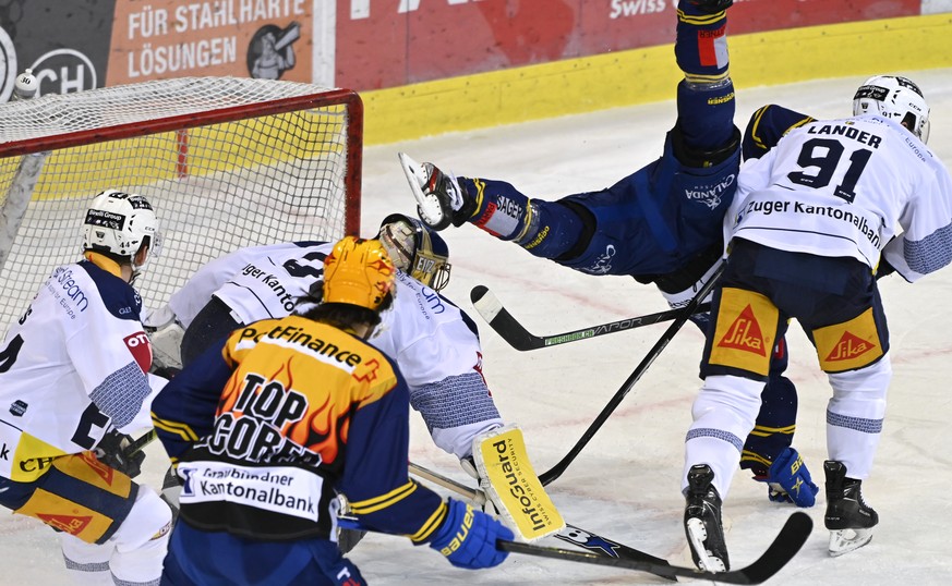 Der Zug Torhueter Gilles Senn, rechts, zwingt den Davoser Dennis Rasmussen (SWE) zum Handstand, beobachtet von Zuger Torhueter Leonardo Genoni, im Eishockey-Qualifikationsspiel der National League zwi ...