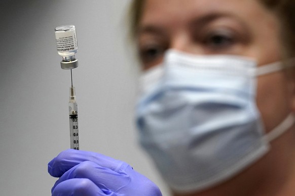 FILE - In this March 2, 2021, file photo, Hollie Maloney, a pharmacy technician, loads a syringe with Pfizer&#039;s COVID-19 vaccine at the Portland Expo in Portland, Maine. An influential federal adv ...