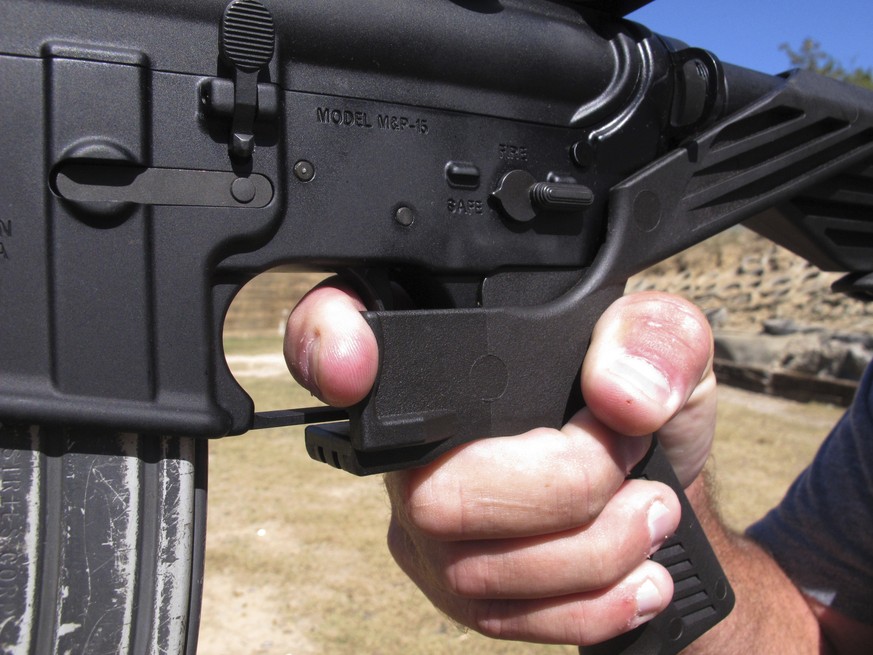 FILE - In this Oct. 4, 2017, file photo, shooting instructor Frankie McRae demonstrates the grip on an AR-15 rifle fitted with a bump stock at his 37 PSR Gun Club in Bunnlevel, N.C. Some states and ci ...