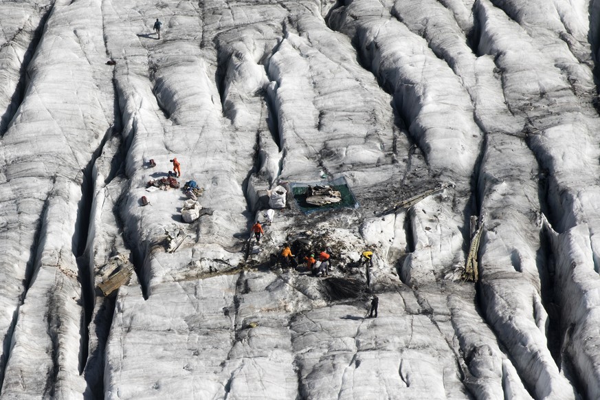 Members of the Swiss army remove the wreckage of the US-WWII warplane C-53 Skytrooper Dakota that crashed in 1946, pictured on the Gauli Glacier in the Bernese Alps, Switzerland, Monday, September 17, ...