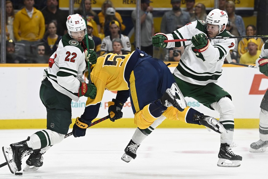 Minnesota Wild defenseman Dmitry Kulikov (7) checks Nashville Predators defenseman Roman Josi (59) into Wild left wing Kevin Fiala (22) during the second period of an NHL hockey game Sunday, April 24, ...