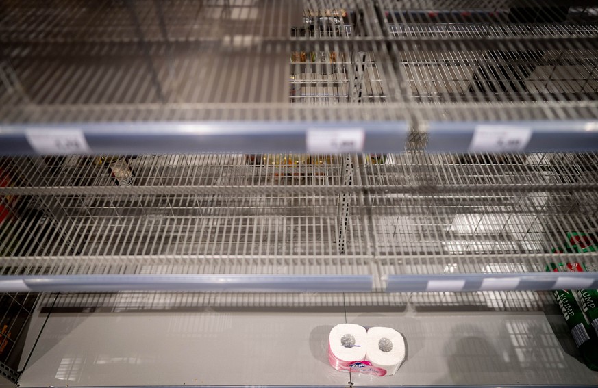 16.03.2020, Berlin: Zwei übrig gebliebene Rollen Toilettenpapier stehen in einem ansonsten leeren Regal in einem Supermarkt im Berliner Stadtteil Friedenau. Neue Ware soll hier im Verlaufe des Tages g ...