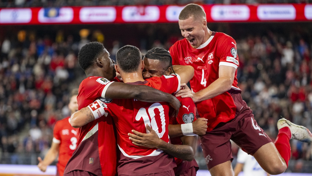 Switzerland's Manuel Akanji, center, celebrates after scoring to 1:0 with teammates from left, Breel Embolo and Granit Xhaka, and Silvan Widmer, right, during the FIFA 2026 World Cup Group B qual ...