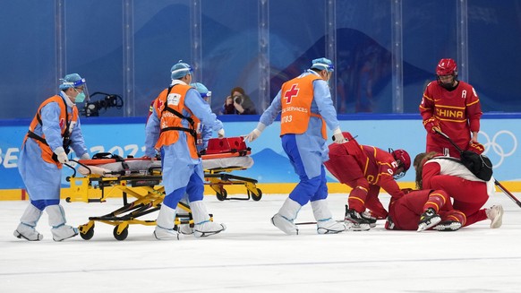 China&#039;s Zhang Mengying is attended to after being injured during a preliminary round women&#039;s hockey game against Japan at the 2022 Winter Olympics, Sunday, Feb. 6, 2022, in Beijing. (AP Phot ...