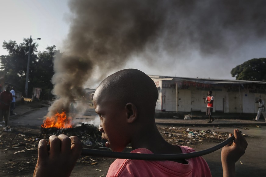Ein Junge schaut auf die brennenden Barrikadenreste nach einer Antiregierungs-Demonstration gegen den burundischen Präsidenten Pierre Nkurunziza in Cibitoke im Mai 2015.&nbsp;