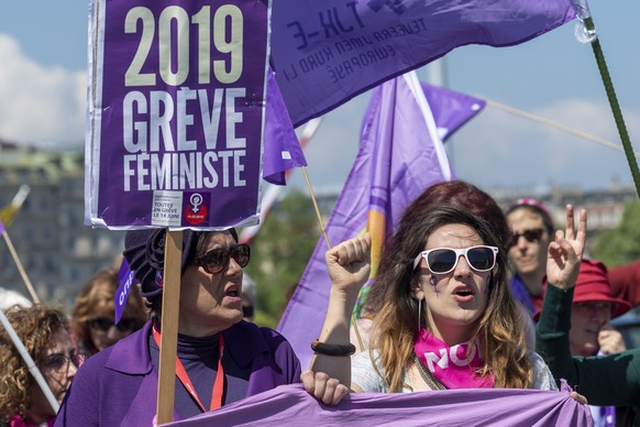 Des manifestants avec des pancartes et des drapeaux defilent dans les rues de Geneve, lors du defile du 1er mai - Fete du Travail , ce mercredi 1 mai 2019 a Geneve. A Geneve, pres de 2&#039;000 person ...