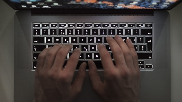 ARCHIVBILD - ZUM THEMA CYBERBEDROHUNGEN MINIMIEREN AN DER SOMMERSESSION DER EIDGENOESSISCHEN RAETE AM DONNERSTAG, 13. JUNI 2019, STELLEN WIR IHNEN FOLGENDES BILDMATERIAL ZUR VERFUEGUNG - A man uses a  ...