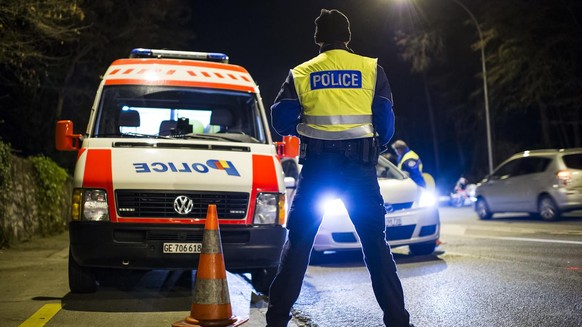 Des policiers controlent des automobilistes lors d&#039;un controle de circulation comprenant la police et la gendarmerie genevoise et vaudoise ainsi que les gardes frontieres ce mardi soir 23 decembr ...
