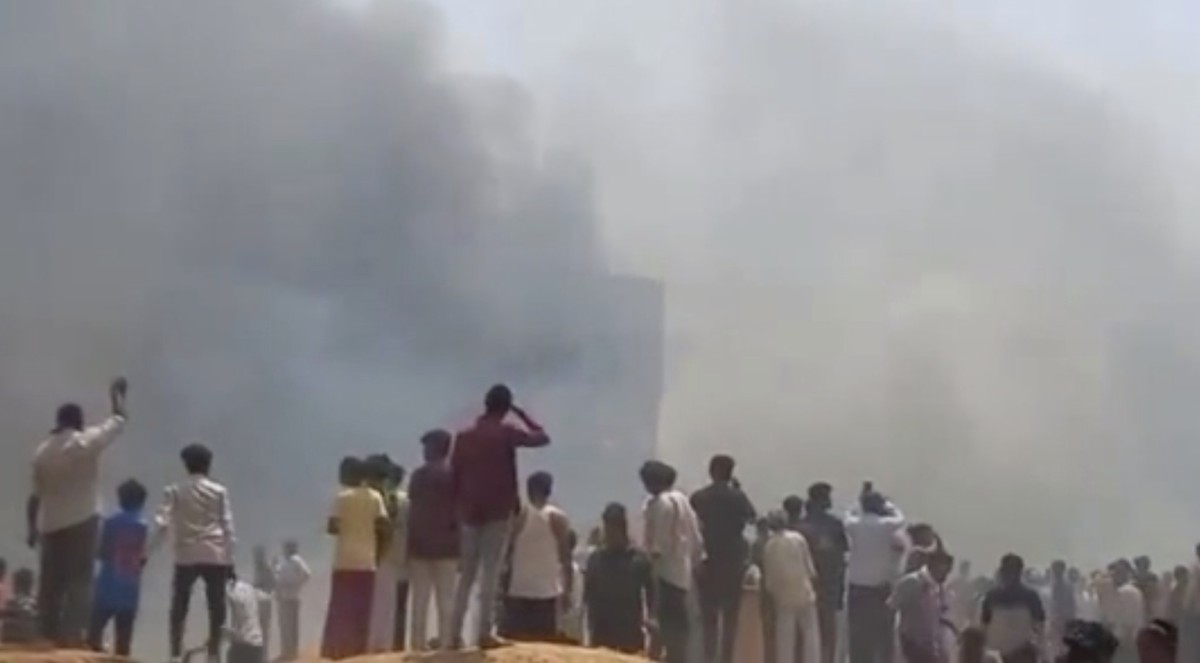 People watch smoke rising after an airplane crashed in Ahmedabad, Gujarat state, India, Thursday, June 12, 2025. (Mohan Nakum via AP)
India Plane Crash