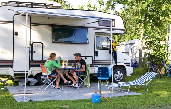 Two young people sit in front of their camper, pictured on the campground &quot;Seeland&quot; in Sempach in the canton of Lucerne, Switzerland on July 23, 2008. (KEYSTONE/Martin Ruetschi)

Zwei junge  ...