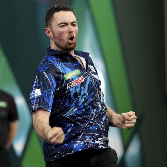 Luke Humphries celebrates defeating Ricardo Pietreczko on day eleven of the World Darts Championship at Alexandra Palace, London, Thursday Dec. 28, 2023. (John Walton/PA via AP)