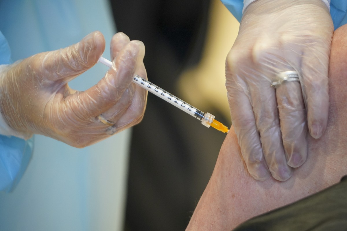 A health worker administers a dose of the AstraZeneca vaccine against COVID-19 to a patient inside the convention center known as "La Nuvola", The Cloud, in Rome, Wednesday, March 10, 2021.  ...